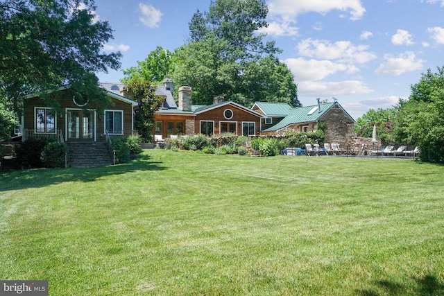 back of property with a yard and a chimney