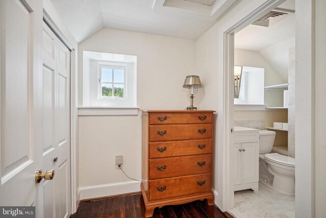 bathroom with lofted ceiling, toilet, vanity, baseboards, and wood finished floors