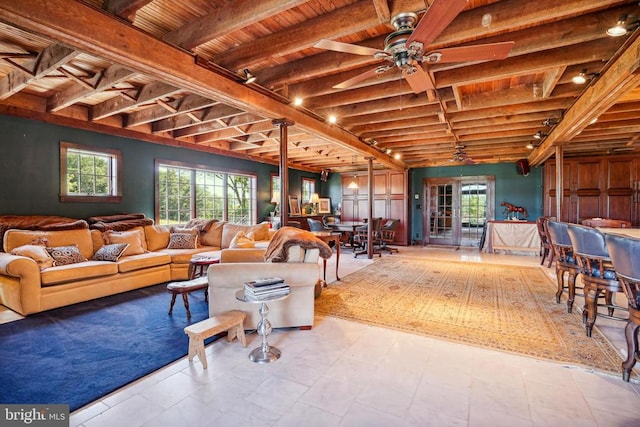 living area with beam ceiling, wooden ceiling, plenty of natural light, and ceiling fan