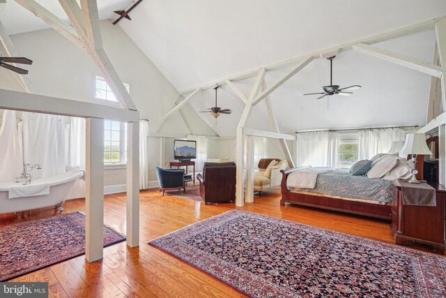 bedroom featuring high vaulted ceiling, beam ceiling, and wood finished floors