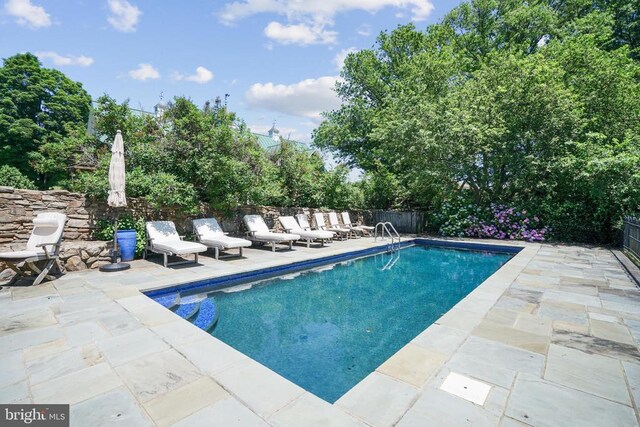 view of pool with a patio area and fence