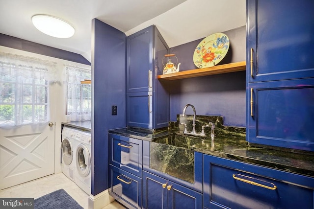 washroom featuring washing machine and clothes dryer, bar with sink, and cabinet space