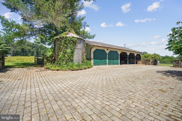 view of front of property with an outbuilding, fence, and a pole building