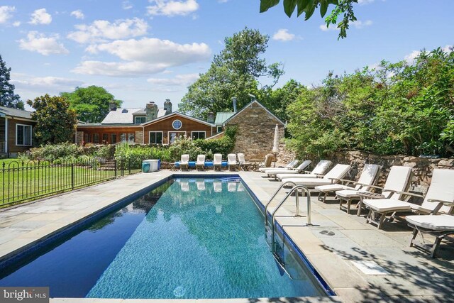 view of swimming pool with a patio area and fence