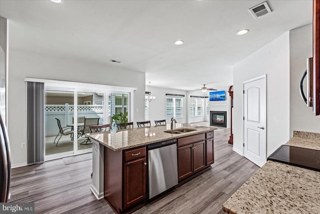 6607 Golden Pheasant Run, Fredericksburg, VA 22407 - kitchen featuring stainless steel appliances, a sink, a glass covered fireplace, wood finished floors, and open floor plan