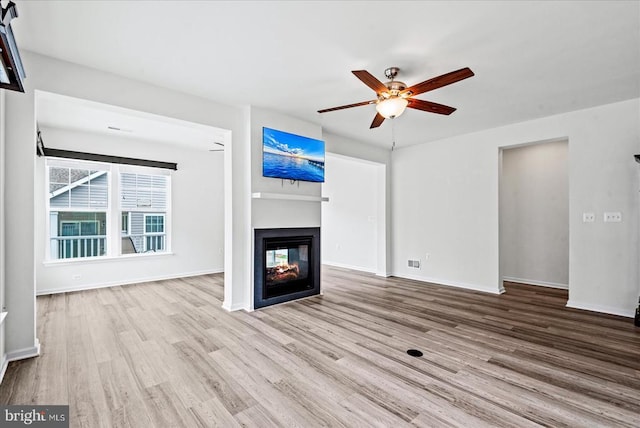 6607 Golden Pheasant Run, Fredericksburg, VA 22407 - unfurnished living room with a multi sided fireplace, wood finished floors, a ceiling fan, and baseboards