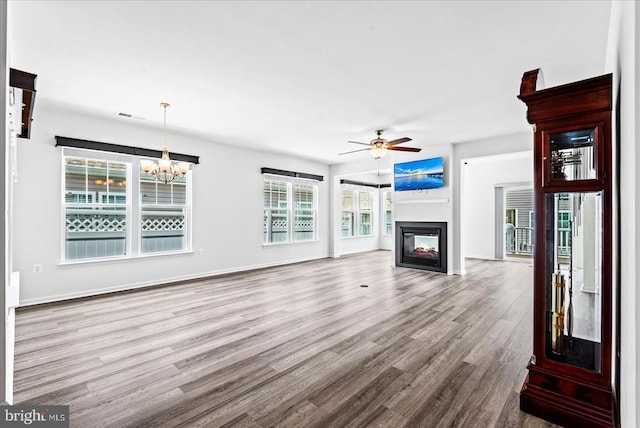 6607 Golden Pheasant Run, Fredericksburg, VA 22407 - unfurnished living room featuring wood finished floors, a chandelier, a multi sided fireplace, a ceiling fan, and baseboards