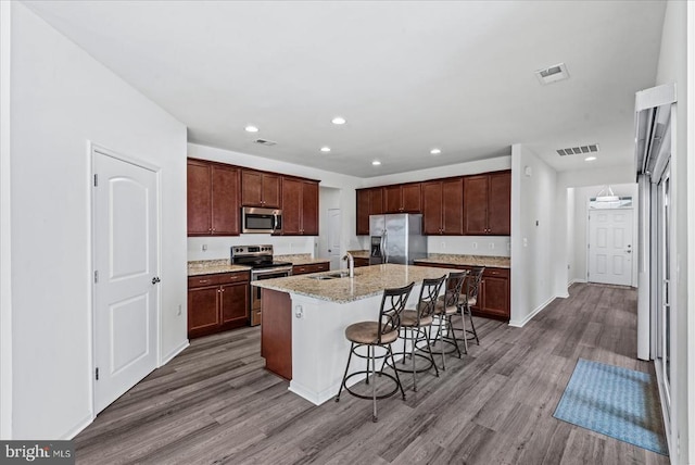 6607 Golden Pheasant Run, Fredericksburg, VA 22407 - kitchen featuring stainless steel appliances, a sink, wood finished floors, a breakfast bar area, and recessed lighting