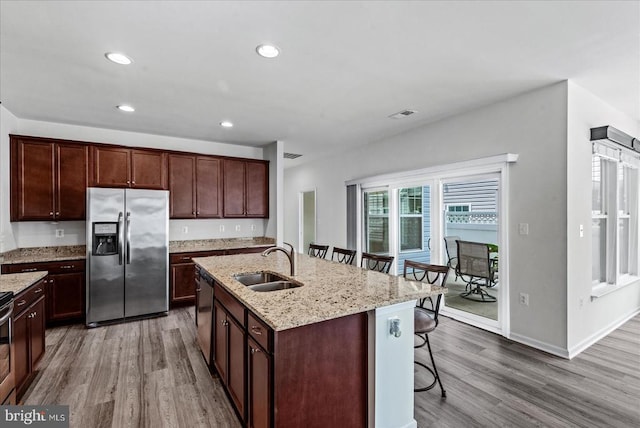 6607 Golden Pheasant Run, Fredericksburg, VA 22407 - kitchen featuring appliances with stainless steel finishes, a sink, a breakfast bar area, wood finished floors, and recessed lighting