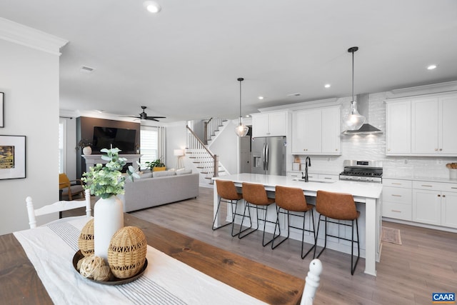 760 Arboleda Dr, Crozet, VA 22932 - kitchen with appliances with stainless steel finishes, wall chimney exhaust hood, a center island with sink, a kitchen bar, and backsplash