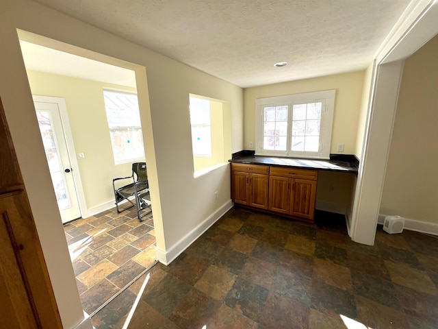 interior space with built in desk and a textured ceiling