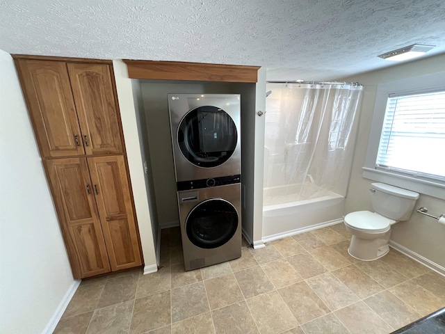 washroom with stacked washer and clothes dryer and a textured ceiling