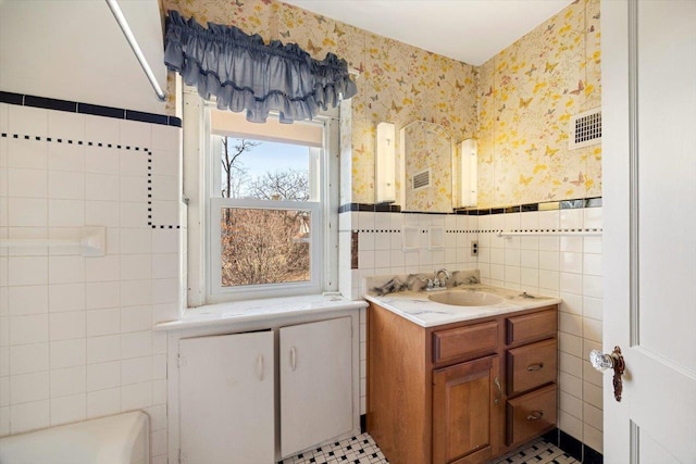 419 College Cir, Staunton, VA 24401 - bathroom with wallpapered walls, vanity, tile walls, a bathtub, and wainscoting