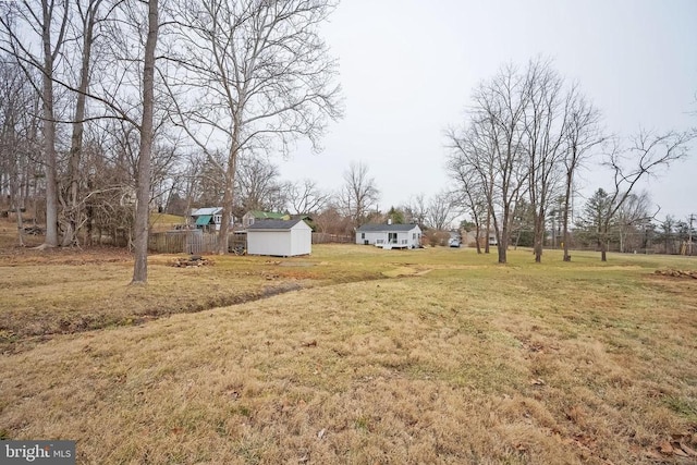 view of grassy yard featuring a storage shed and an outdoor structure