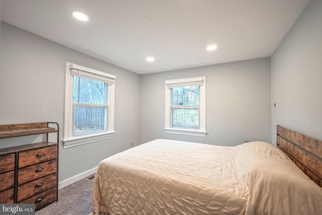 bedroom with dark carpet, multiple windows, baseboards, and recessed lighting