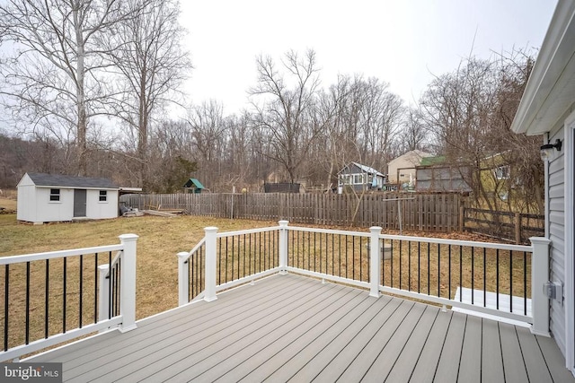 wooden terrace featuring an outdoor structure, a storage unit, and a playground