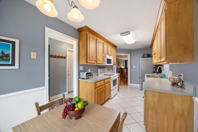 35 Hickory Nut Ln, Staunton, VA 24401 - kitchen featuring white appliances, light tile patterned floors, light countertops, a sink, and wainscoting