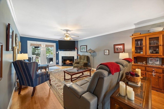 35 Hickory Nut Ln, Staunton, VA 24401 - living room with light wood-type flooring, a ceiling fan, ornamental molding, a warm lit fireplace, and baseboards