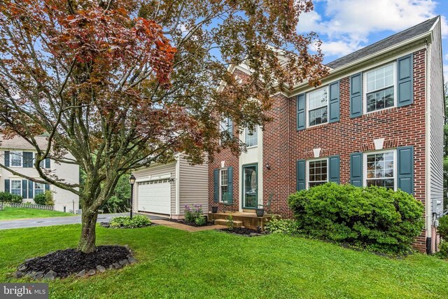  - view of front of property with a front yard, driveway, and brick siding