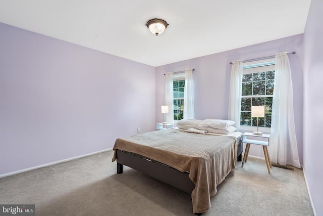  - bedroom featuring light colored carpet and baseboards