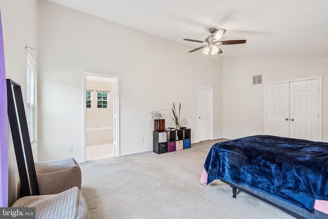  - carpeted bedroom with high vaulted ceiling, ensuite bathroom, ceiling fan, and a closet