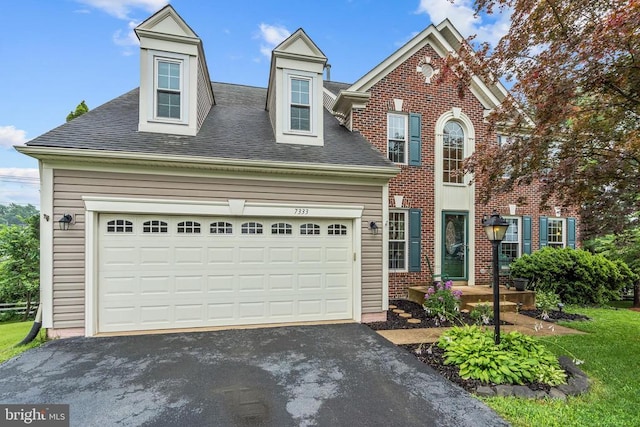  - view of front of home with driveway, roof with shingles, brick siding, and an attached garage