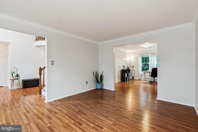  - unfurnished living room with ornamental molding, wood finished floors, stairway, and a desk