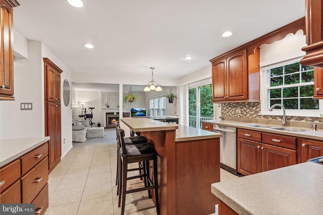  - kitchen featuring stainless steel dishwasher, a kitchen island, decorative backsplash, open floor plan, and a breakfast bar