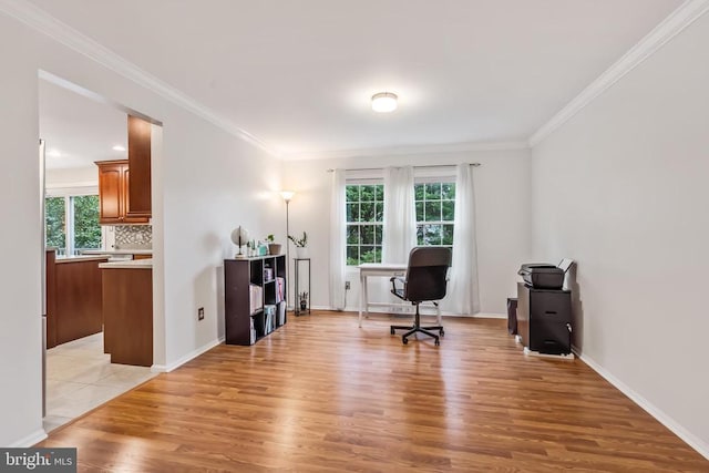  - office area featuring light wood finished floors, healthy amount of natural light, and crown molding