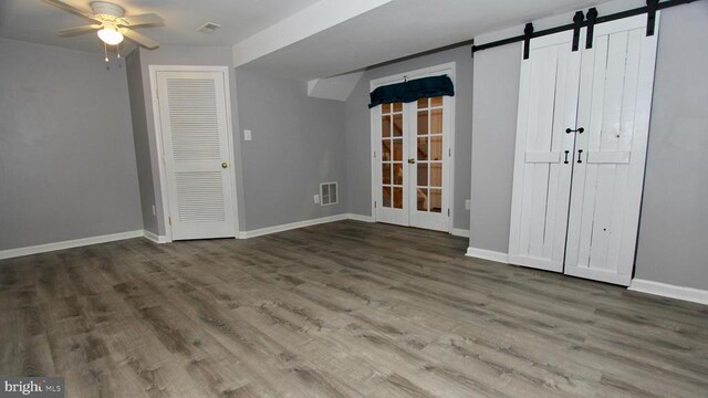 4605 Club Cart Cir, Fredericksburg, VA 22408 - empty room with wood finished floors, french doors, ceiling fan, and a barn door
