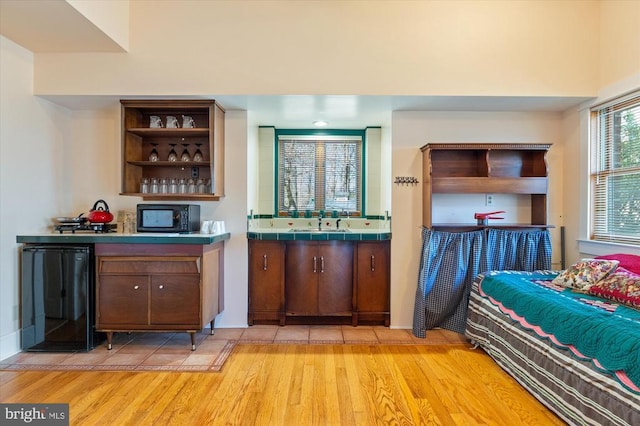 5864 Wyant Ln, Charlottesville, VA 22903 - indoor wet bar with black microwave, light wood finished floors, and fridge