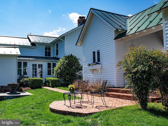 435 Larkins Mill Ln, Brightwood, VA 22715 - back of property with a chimney, metal roof, a standing seam roof, a yard, and a patio area