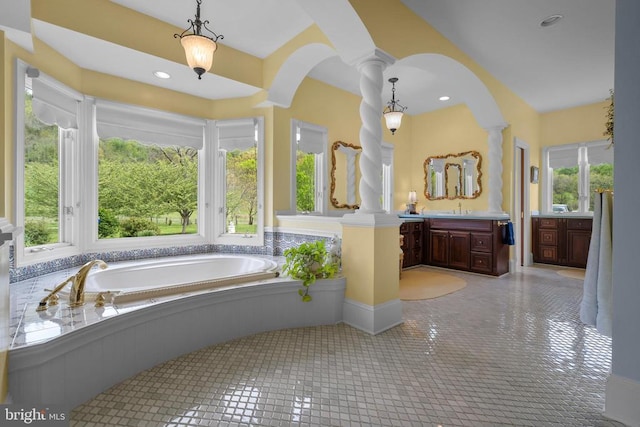  - bathroom with decorative columns, vanity, and a bath
