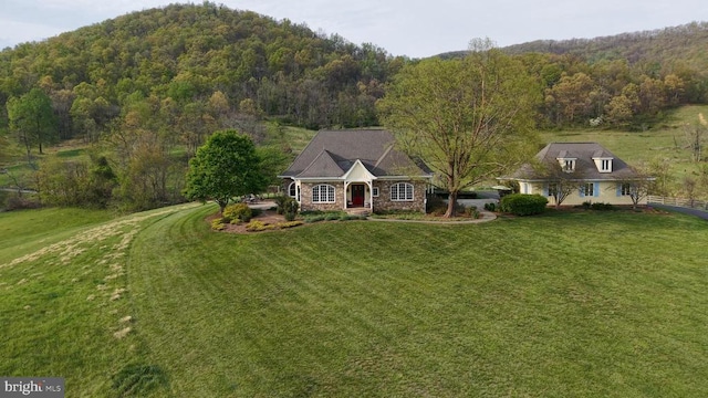  - view of front of house with a view of trees and a front lawn