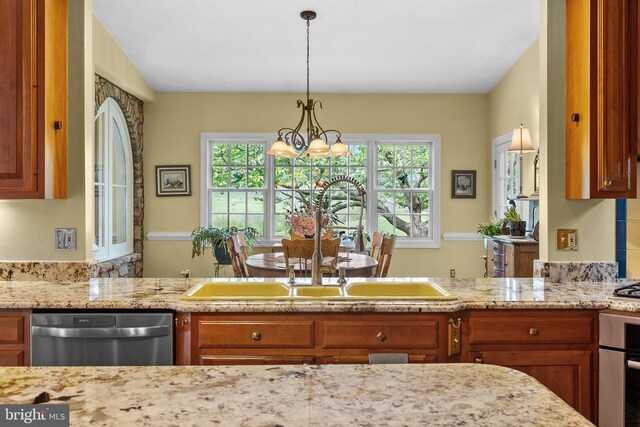  - kitchen featuring dishwasher, brown cabinets, and light stone counters