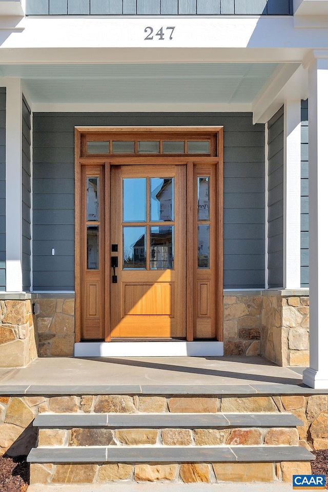 property entrance featuring stone siding