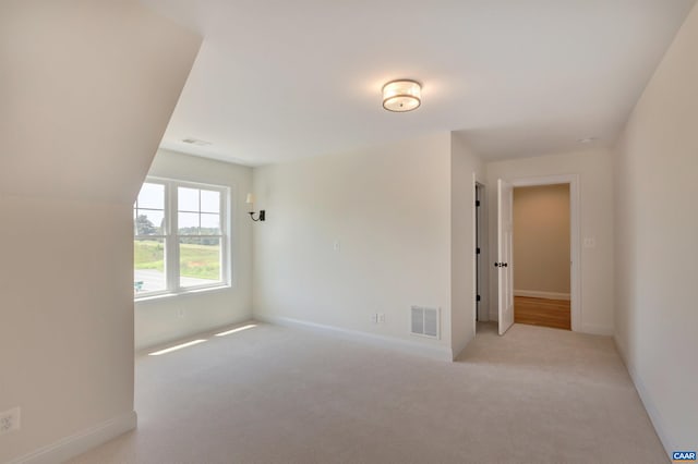 unfurnished room with carpet flooring, visible vents, and baseboards