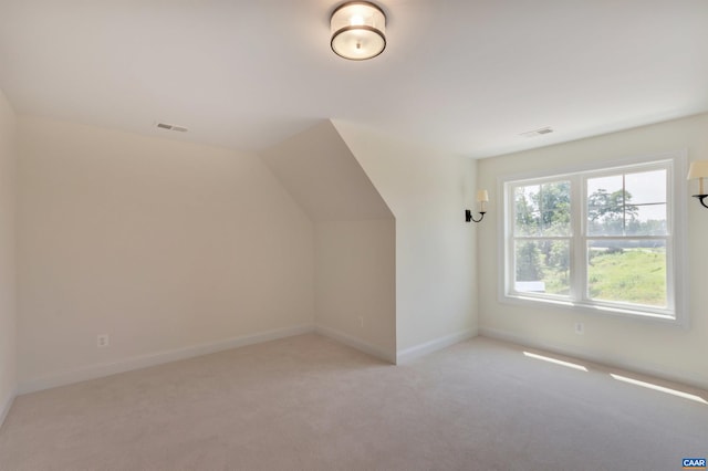 bonus room featuring vaulted ceiling, light carpet, baseboards, and visible vents