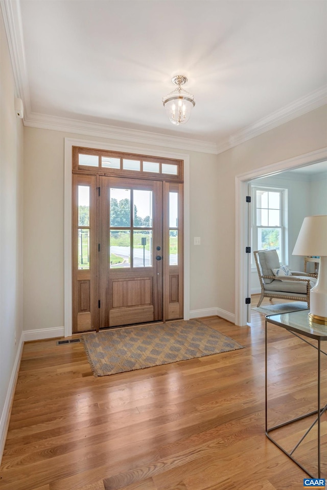 foyer with baseboards, a notable chandelier, and crown molding