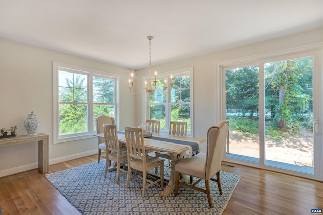 dining space featuring an inviting chandelier, baseboards, and light wood-type flooring