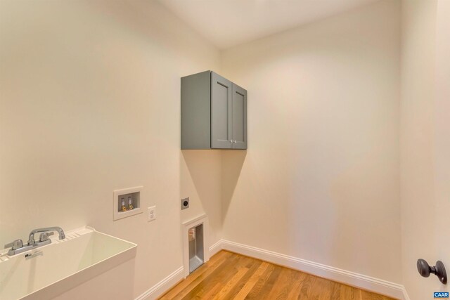 washroom featuring baseboards, washer hookup, light wood-type flooring, cabinet space, and electric dryer hookup