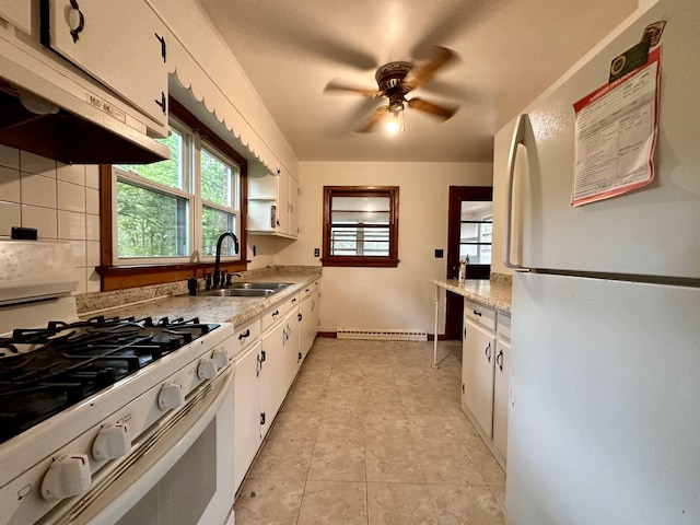 kitchen with white appliances, a sink, exhaust hood, white cabinets, and light countertops