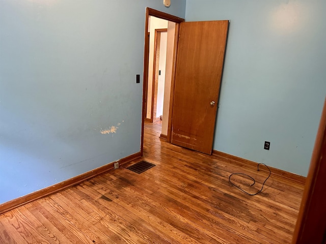 spare room featuring wood finished floors and baseboards