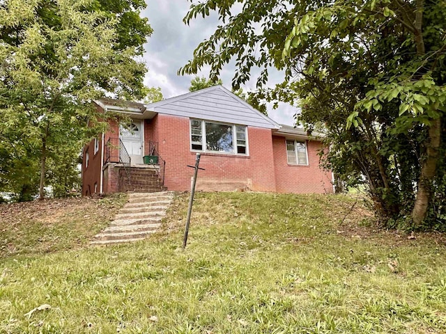 view of front of house with brick siding and a front lawn