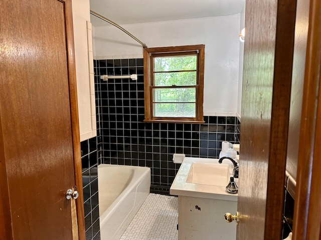 bathroom featuring tile walls, tile patterned floors, vanity, and a wainscoted wall