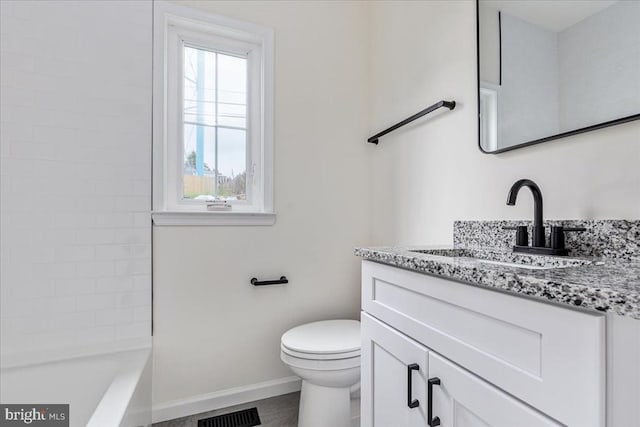 bathroom with baseboards, vanity, and toilet