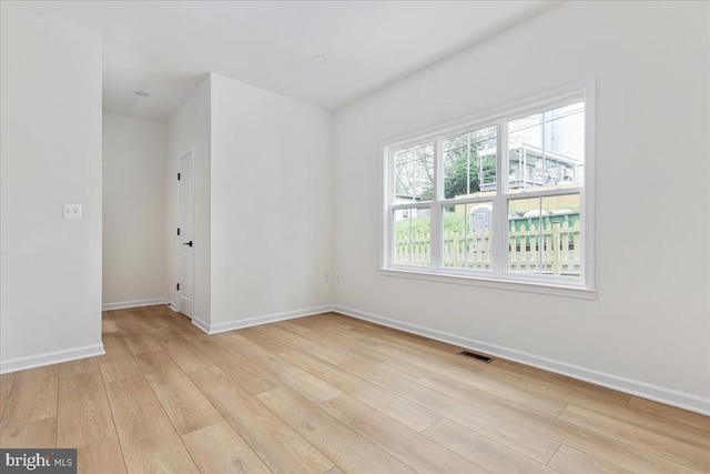 spare room with light wood finished floors and baseboards