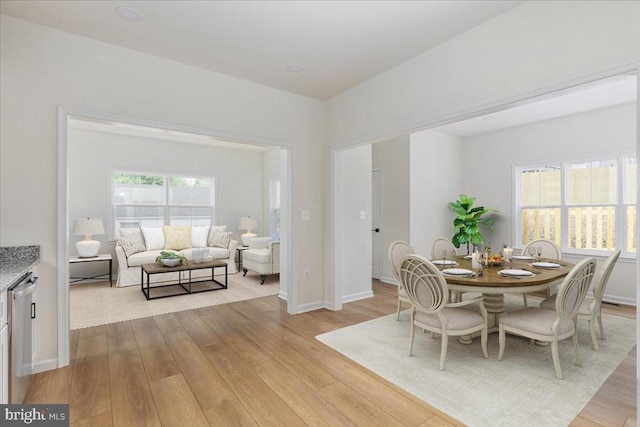 dining area featuring light wood-style floors and baseboards