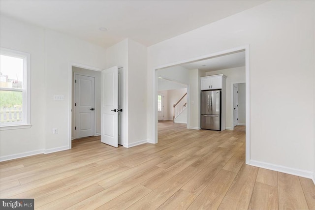 spare room featuring light wood-style flooring and baseboards