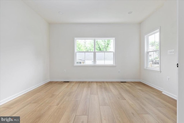 spare room featuring light wood-type flooring and baseboards